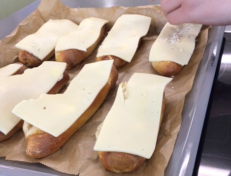 8 Laugenstangen mit Käse und Salz vor dem Backen auf einem Backpapier © Nora Leiner